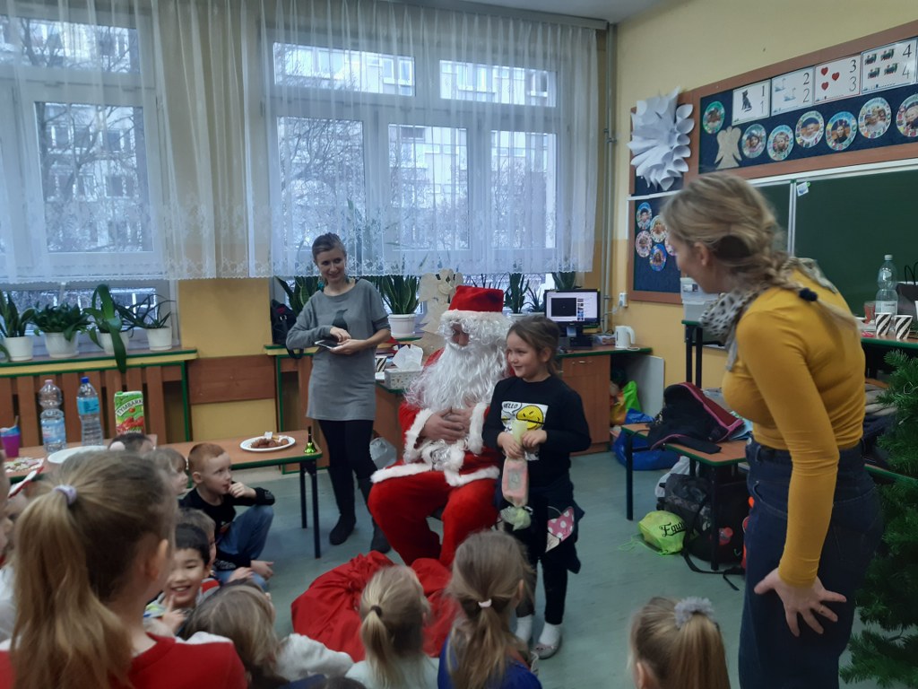 Święty Mikołaj rozdaje prezenty uczniom klasy 1b
